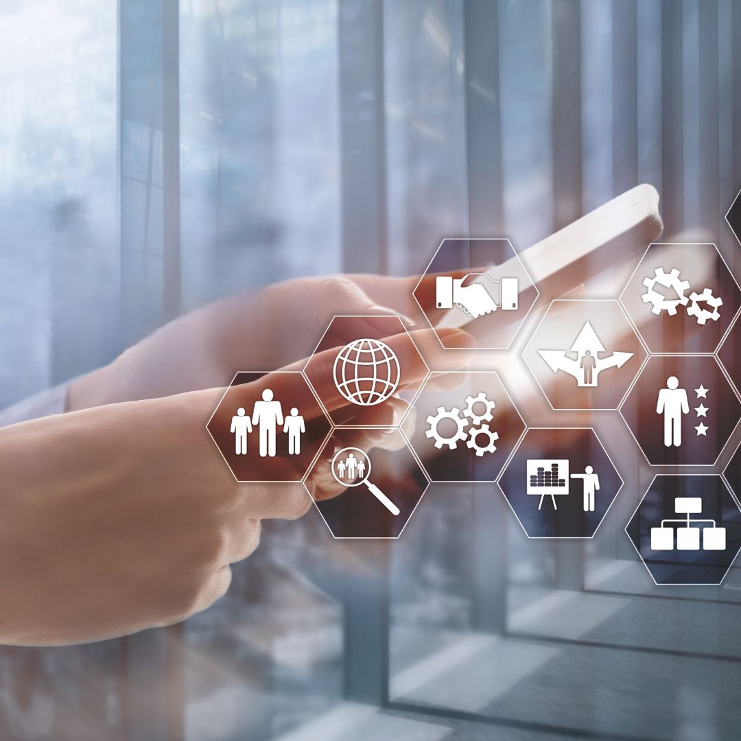 Hands tapping a device with floating hexagonal icons for global business, teamwork, and analytics (digital collaboration concept)